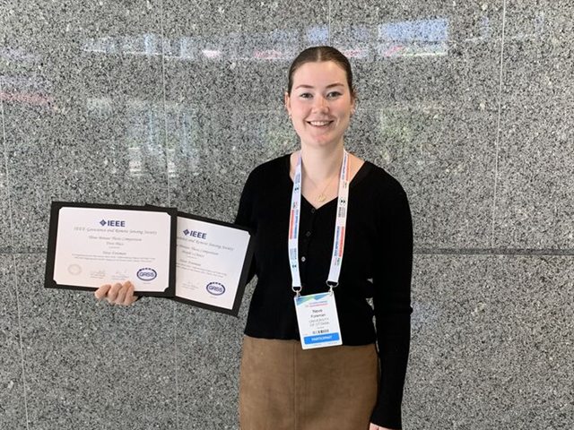 Neve Foreman holding her two IEEE GRSS Three Minute Thesis certificates at ISPRS 2026